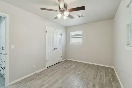 107 Cimarron Ter, Cashion, OK 73016 - unfurnished bedroom featuring light wood finished floors, a closet, and ceiling fan