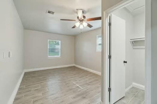 107 Cimarron Ter, Cashion, OK 73016 - unfurnished bedroom featuring multiple windows, light wood-type flooring, and a closet