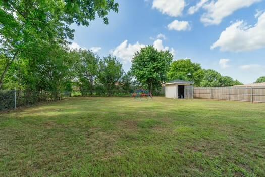 107 Cimarron Ter, Cashion, OK 73016 - fenced backyard featuring an outdoor structure