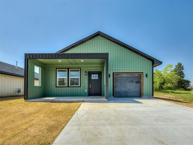 532 NW 112th St, Oklahoma City, OK 73114 - view of front of house featuring covered porch, a front lawn, an attached garage, board and batten siding, and concrete driveway