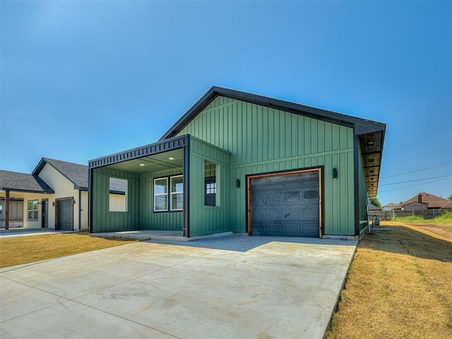532 NW 112th St, Oklahoma City, OK 73114 - view of front of property with board and batten siding, a garage, a front lawn, and driveway