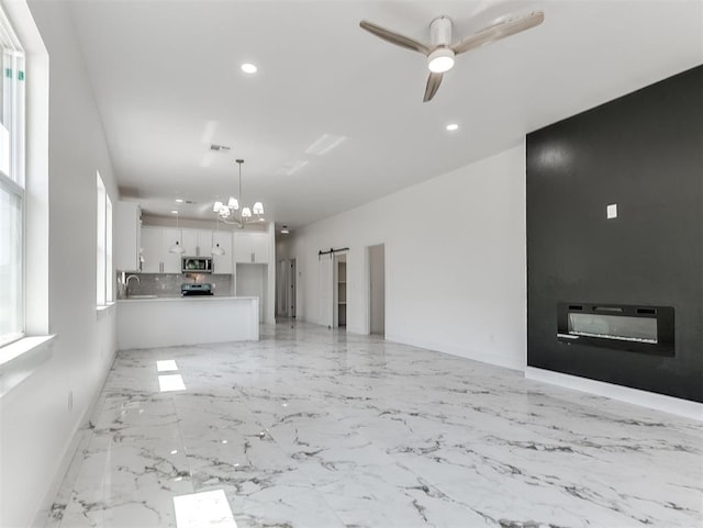 532 NW 112th St, Oklahoma City, OK 73114 - unfurnished living room featuring a chandelier, recessed lighting, a ceiling fan, a barn door, and light marble finish floors