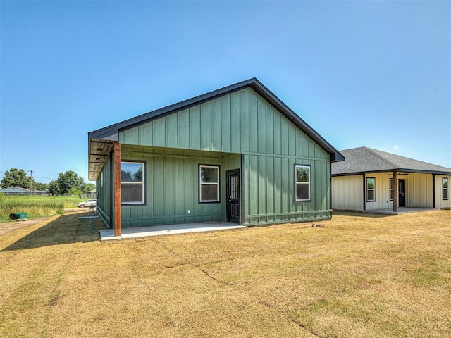 532 NW 112th St, Oklahoma City, OK 73114 - rear view of property with a patio area, board and batten siding, and a yard