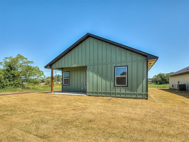 532 NW 112th St, Oklahoma City, OK 73114 - rear view of house with board and batten siding, a yard, and a patio