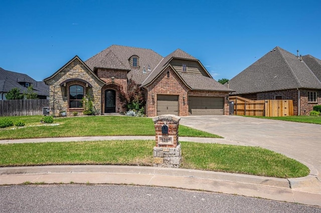 3205 Sycamore Dr, Moore, OK 73160 - french country inspired facade featuring concrete driveway, brick siding, a garage, and stone siding