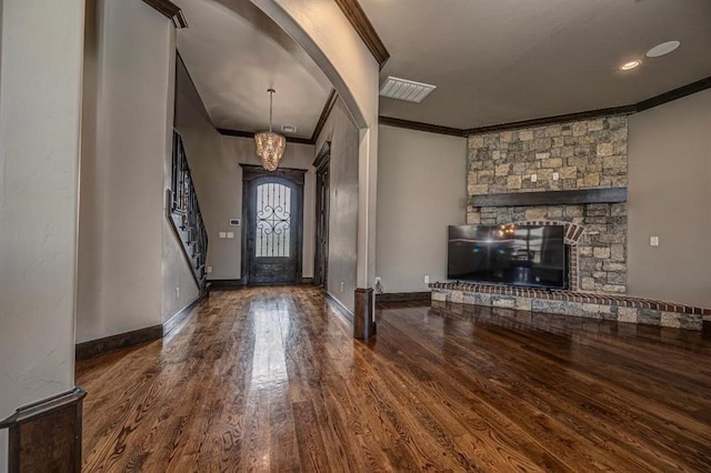3205 Sycamore Dr, Moore, OK 73160 - foyer featuring crown molding, wood finished floors, arched walkways, and a stone fireplace