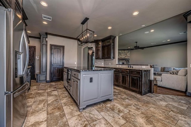 3205 Sycamore Dr, Moore, OK 73160 - kitchen featuring stainless steel refrigerator with ice dispenser, ceiling fan, a kitchen island, backsplash, and crown molding