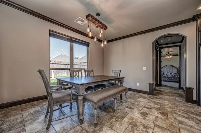3205 Sycamore Dr, Moore, OK 73160 - dining area with ornamental molding, arched walkways, stone tile floors, and ceiling fan
