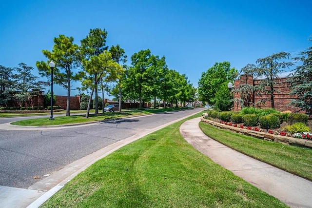 3205 Sycamore Dr, Moore, OK 73160 - view of asphalt road featuring street lighting, sidewalks, and curbs