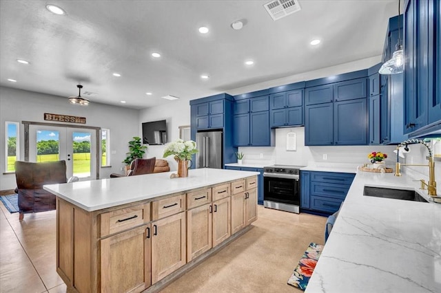 831 County St Unit 2917, Tuttle, OK 73089 - kitchen with appliances with stainless steel finishes, recessed lighting, french doors, a kitchen island, and light stone counters