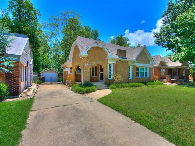 2420 NW 21st St, Oklahoma City, OK 73107 - view of front of property featuring brick siding, an outbuilding, a front lawn, a detached garage, and a shingled roof