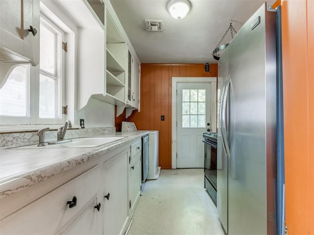 2420 NW 21st St, Oklahoma City, OK 73107 - kitchen with freestanding refrigerator, open shelves, black electric range, light countertops, and white cabinets