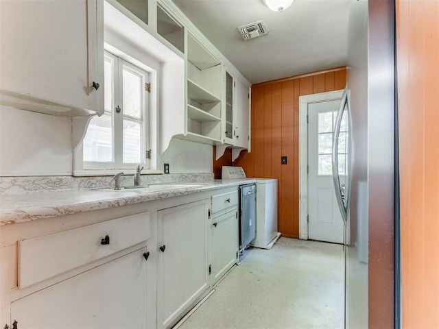 2420 NW 21st St, Oklahoma City, OK 73107 - kitchen featuring open shelves, light countertops, wooden walls, and white cabinetry