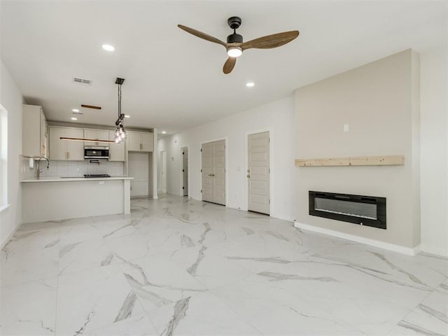 426 NW 115th St, Oklahoma City, OK 73114 - unfurnished living room with a glass covered fireplace, recessed lighting, light marble finish floors, and a ceiling fan