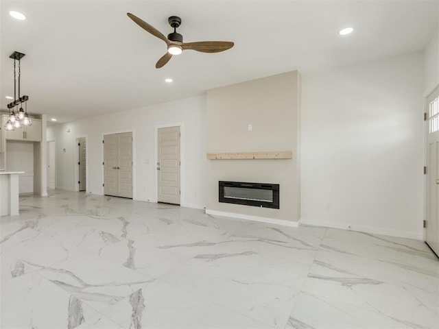 426 NW 115th St, Oklahoma City, OK 73114 - unfurnished living room featuring a glass covered fireplace, recessed lighting, a ceiling fan, and light marble finish flooring