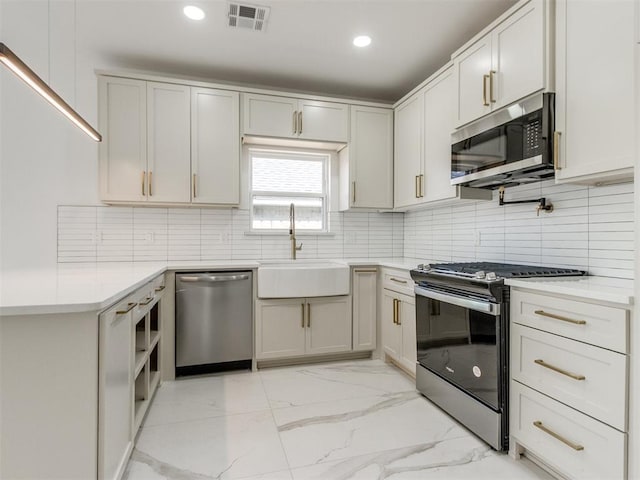 426 NW 115th St, Oklahoma City, OK 73114 - kitchen with appliances with stainless steel finishes, light marble finish floors, light countertops, decorative backsplash, and recessed lighting