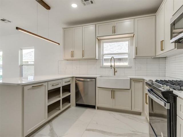 426 NW 115th St, Oklahoma City, OK 73114 - kitchen featuring appliances with stainless steel finishes, light marble finish flooring, a peninsula, light countertops, and recessed lighting