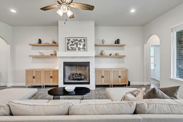 6605 NW 147th St, Oklahoma City, OK 73013 - living area with arched walkways, recessed lighting, ceiling fan, a high end fireplace, and wood finished floors