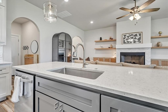 6605 NW 147th St, Oklahoma City, OK 73013 - kitchen with a fireplace, arched walkways, light stone countertops, stainless steel dishwasher, and recessed lighting