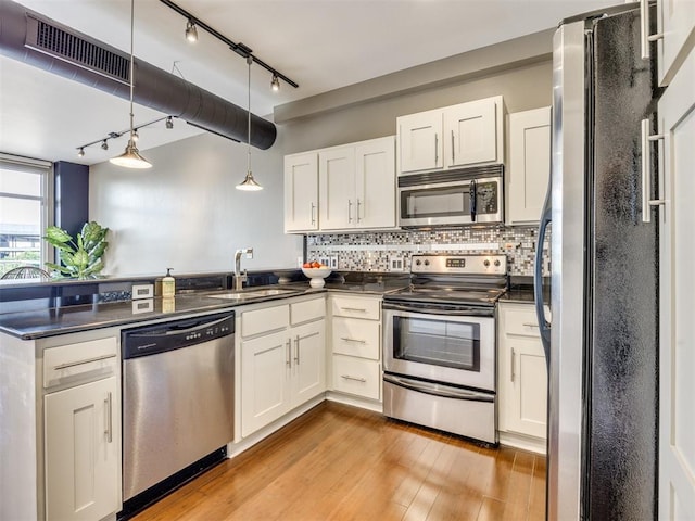 1 NE 2nd St Unit 309, Oklahoma City, OK 73104 - kitchen with stainless steel appliances, dark countertops, a peninsula, and white cabinetry