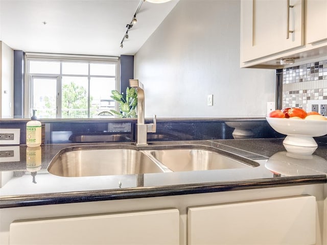 1 NE 2nd St Unit 309, Oklahoma City, OK 73104 - kitchen with rail lighting, dark countertops, and white cabinets