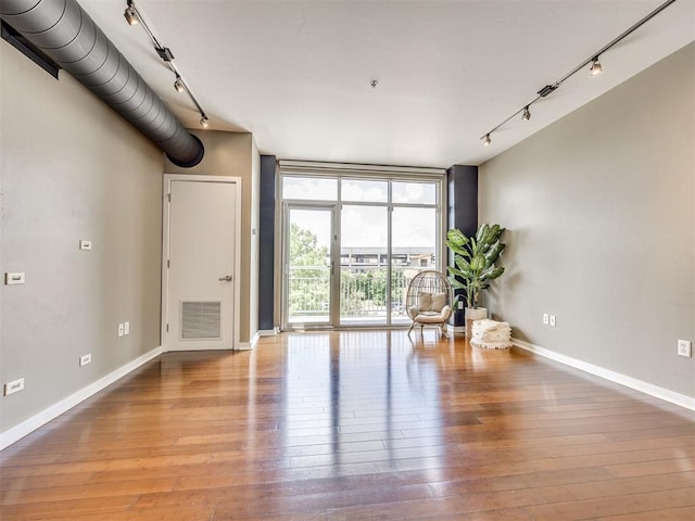1 NE 2nd St Unit 309, Oklahoma City, OK 73104 - unfurnished living room with track lighting, hardwood / wood-style floors, and floor to ceiling windows