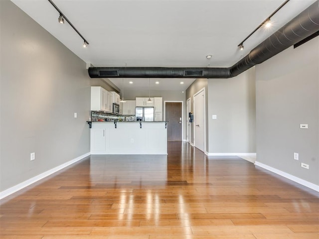 1 NE 2nd St Unit 309, Oklahoma City, OK 73104 - unfurnished living room featuring rail lighting and light wood-style floors