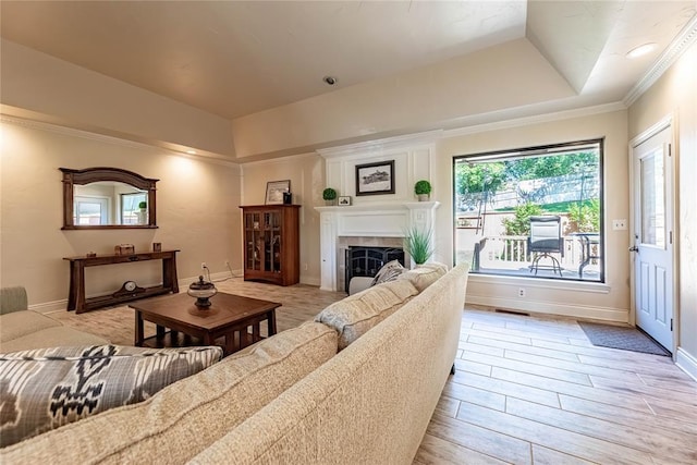 1600 Turtlecreek Rd, Edmond, OK 73013 - living room with a tray ceiling, a tile fireplace, light wood-style floors, and crown molding