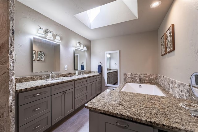 1600 Turtlecreek Rd, Edmond, OK 73013 - bathroom featuring a skylight, double vanity, and a garden tub