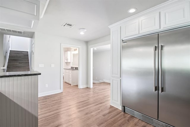 810 S Lahoma Ave, Norman, OK 73069 - kitchen featuring stainless steel built in fridge, white cabinetry, light wood-style floors, recessed lighting, and dark stone counters