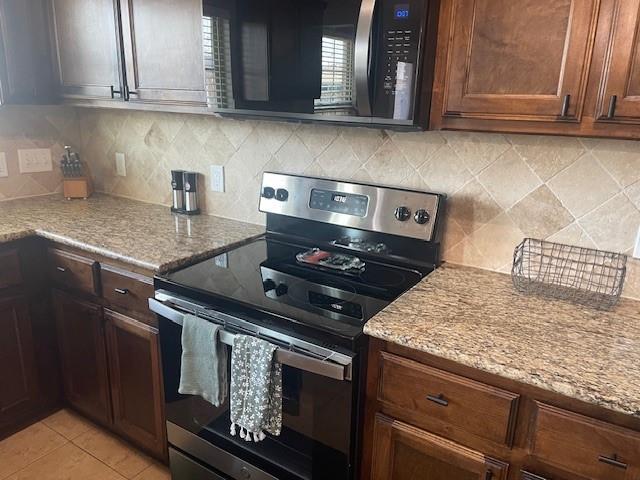 11820 SW 8th St, Yukon, OK 73099 - kitchen featuring stainless steel electric range, tasteful backsplash, and light stone counters