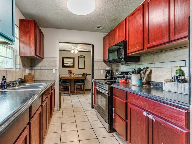 5305 S Drexel Ave, Oklahoma City, OK 73119 - kitchen with stainless steel range with electric stovetop, reddish brown cabinets, black microwave, a textured ceiling, and dark countertops