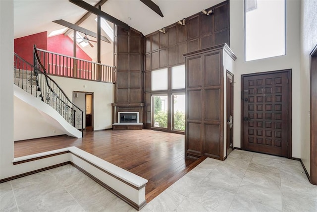 1615 Fox Hollow Rdg, Oklahoma City, OK 73131 - entryway featuring high vaulted ceiling, ceiling fan, beam ceiling, stairs, and a fireplace