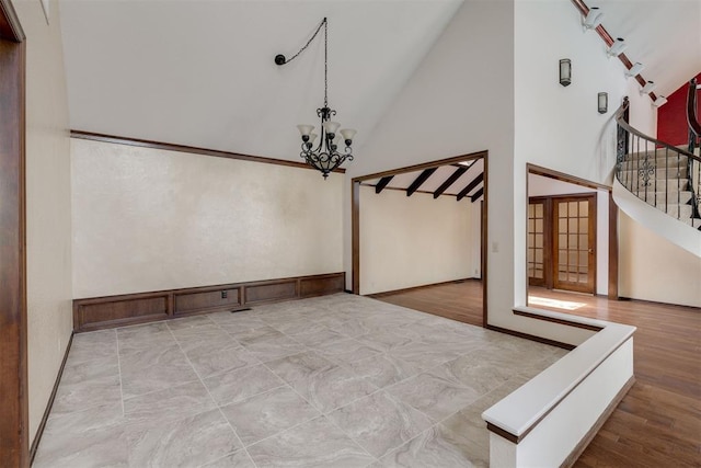 1615 Fox Hollow Rdg, Oklahoma City, OK 73131 - unfurnished dining area featuring high vaulted ceiling, a chandelier, stairway, and wood finished floors