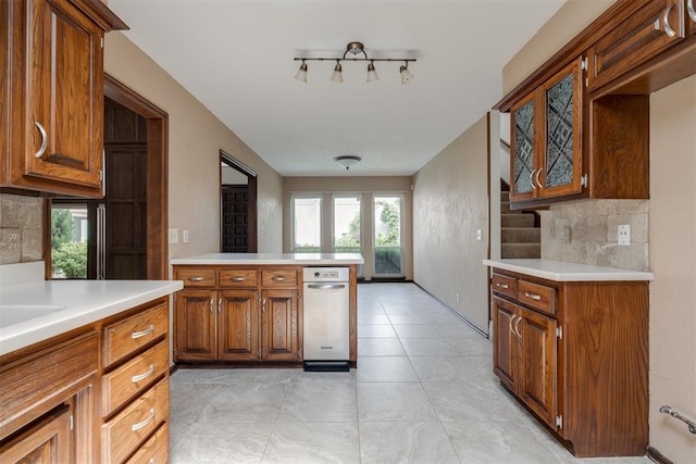 1615 Fox Hollow Rdg, Oklahoma City, OK 73131 - kitchen featuring light countertops, decorative backsplash, and brown cabinetry