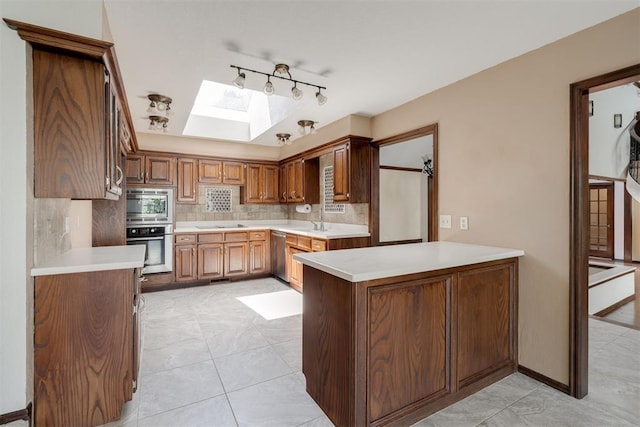 1615 Fox Hollow Rdg, Oklahoma City, OK 73131 - kitchen with stainless steel appliances, a skylight, tasteful backsplash, and light countertops