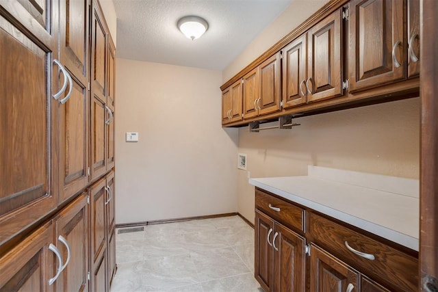 1615 Fox Hollow Rdg, Oklahoma City, OK 73131 - laundry room with cabinet space, washer hookup, and a textured ceiling