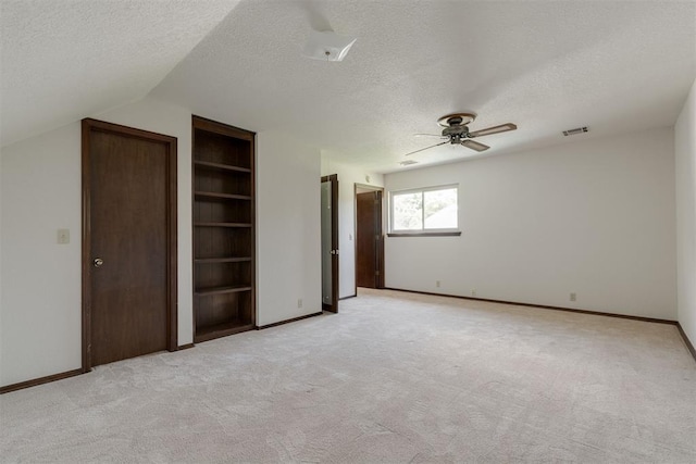 1615 Fox Hollow Rdg, Oklahoma City, OK 73131 - unfurnished bedroom featuring a textured ceiling, light carpet, ceiling fan, and lofted ceiling