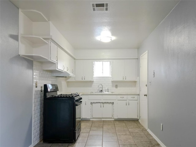 601 SE 70th St, Oklahoma City, OK 73149 - kitchen featuring black gas range, tasteful backsplash, white cabinetry, light countertops, and light tile patterned floors