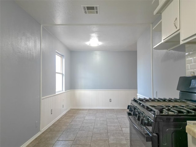 601 SE 70th St, Oklahoma City, OK 73149 - kitchen featuring black gas stove and a wainscoted wall