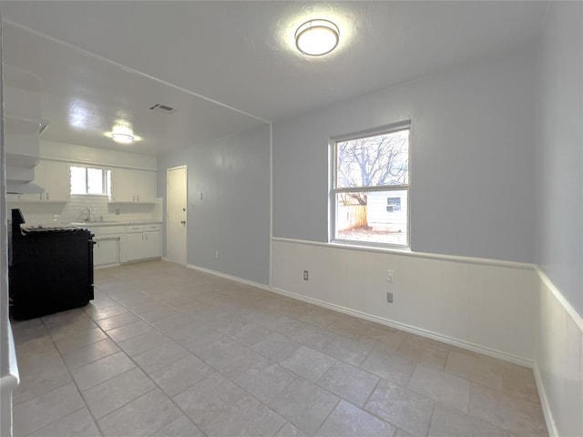 601 SE 70th St, Oklahoma City, OK 73149 - interior space featuring stove, white cabinetry, light countertops, and open shelves