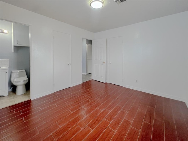 601 SE 70th St, Oklahoma City, OK 73149 - unfurnished bedroom featuring wood finished floors and ensuite bath
