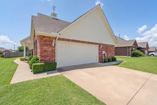 11416 Leslie Beachler Ln, Midwest City, OK 73130 - view of home's exterior with brick siding, an attached garage, concrete driveway, and a lawn