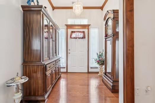 11416 Leslie Beachler Ln, Midwest City, OK 73130 - entrance foyer with crown molding, light wood-style flooring, and a chandelier