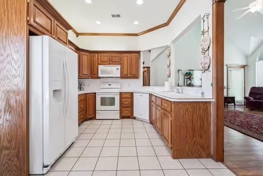 11416 Leslie Beachler Ln, Midwest City, OK 73130 - kitchen with white appliances, ornamental molding, brown cabinets, light countertops, and light tile patterned floors