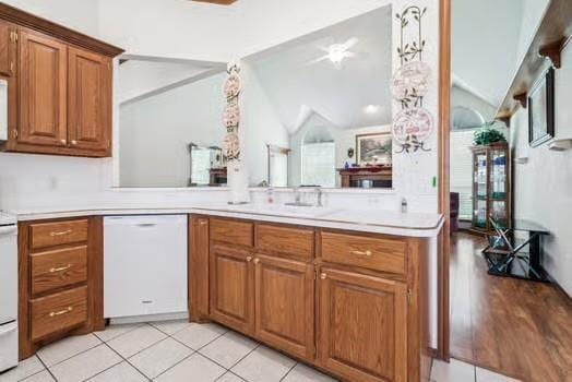 11416 Leslie Beachler Ln, Midwest City, OK 73130 - kitchen featuring dishwasher, lofted ceiling, brown cabinets, light countertops, and light tile patterned floors