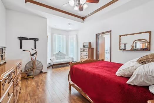 11416 Leslie Beachler Ln, Midwest City, OK 73130 - bedroom featuring wood finished floors, ornamental molding, a tray ceiling, and ceiling fan