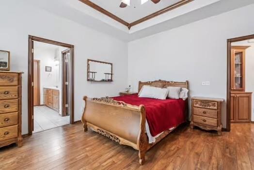 11416 Leslie Beachler Ln, Midwest City, OK 73130 - bedroom featuring a raised ceiling, light wood finished floors, ceiling fan, and ensuite bath