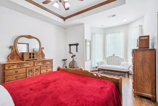 11416 Leslie Beachler Ln, Midwest City, OK 73130 - bedroom featuring a tray ceiling, light wood-style floors, crown molding, and a ceiling fan
