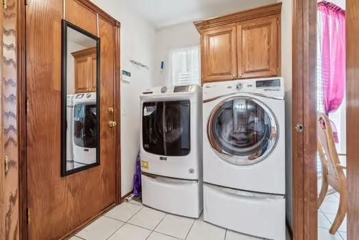 11416 Leslie Beachler Ln, Midwest City, OK 73130 - washroom featuring washer and clothes dryer, light tile patterned floors, and cabinet space